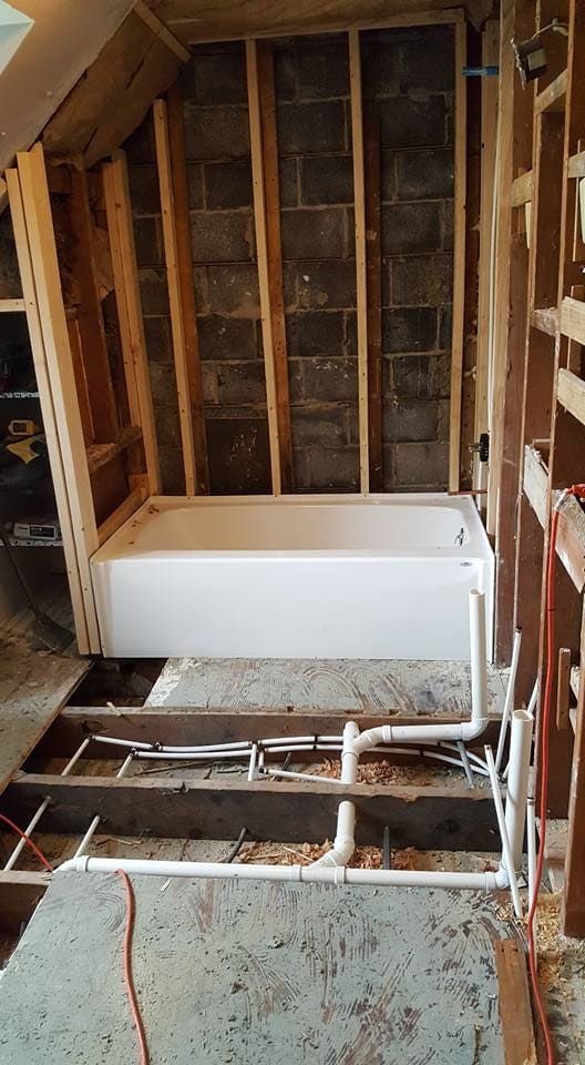 New tub set in place with plumbing rough-in visible