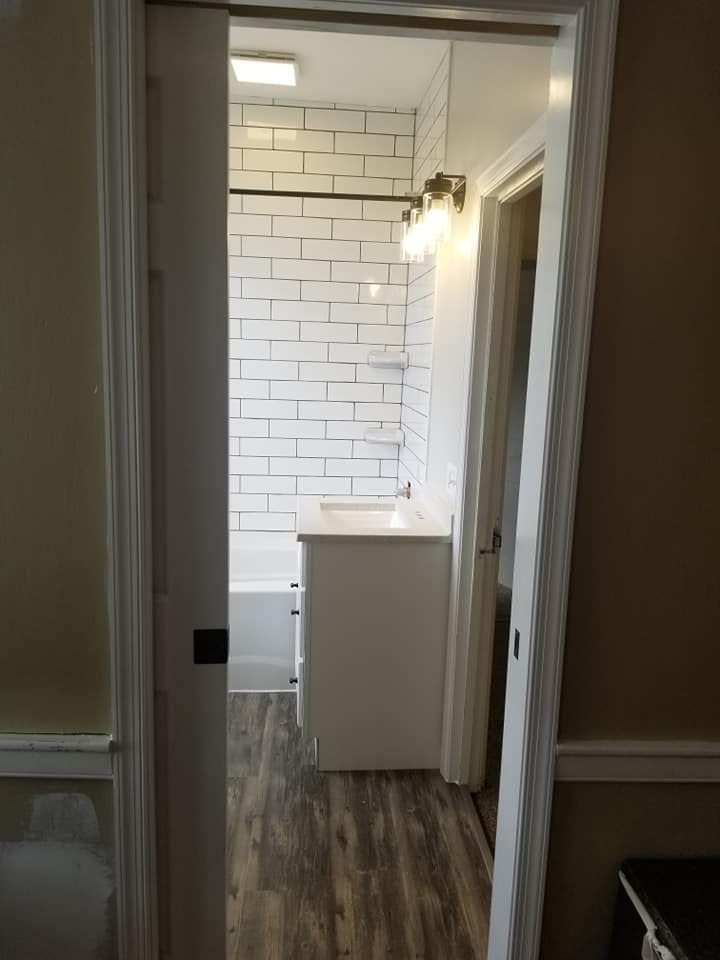 Finished bathroom with white subway tile walls and new tub