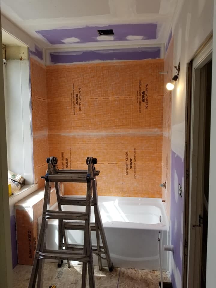 Orange sheet waterproofing membrane on bathroom walls before tile