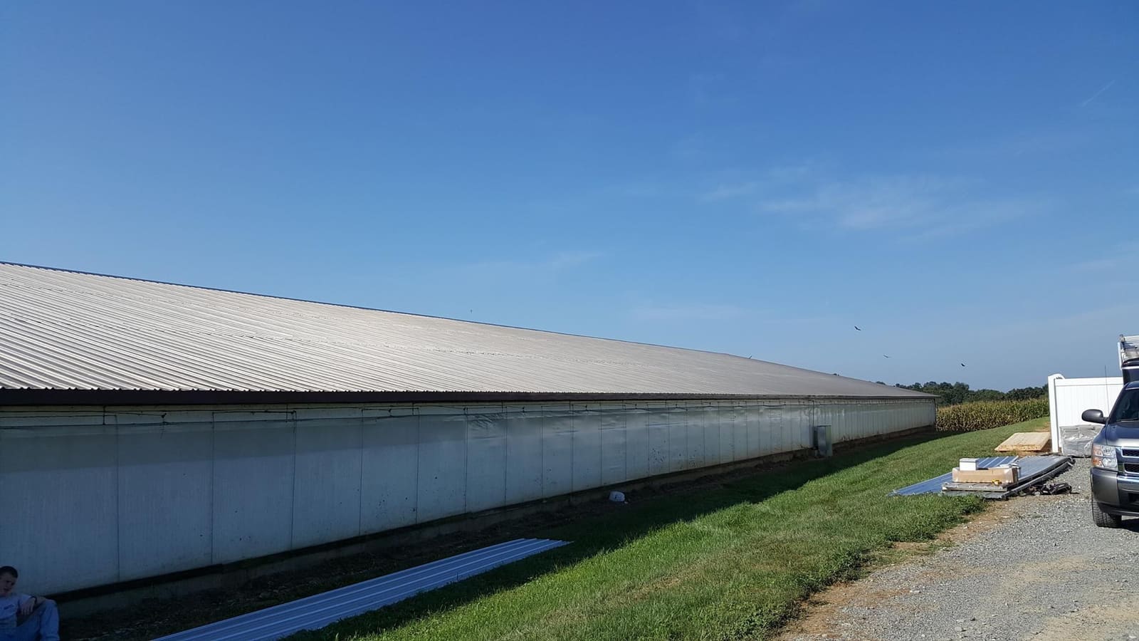 A long new metal roof on a Lancaster County agricultural building under a clear sky