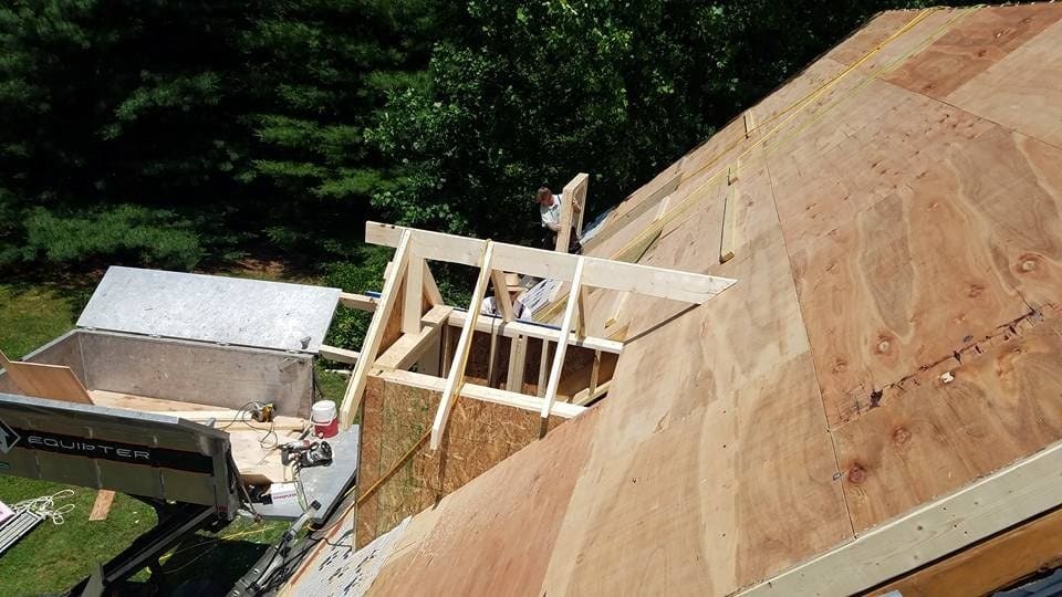 New plywood decking being installed on a roof
