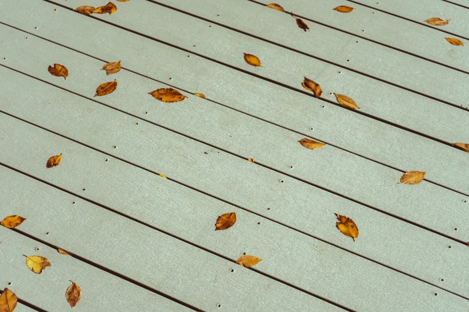 Grey composite deck boards with fall leaves