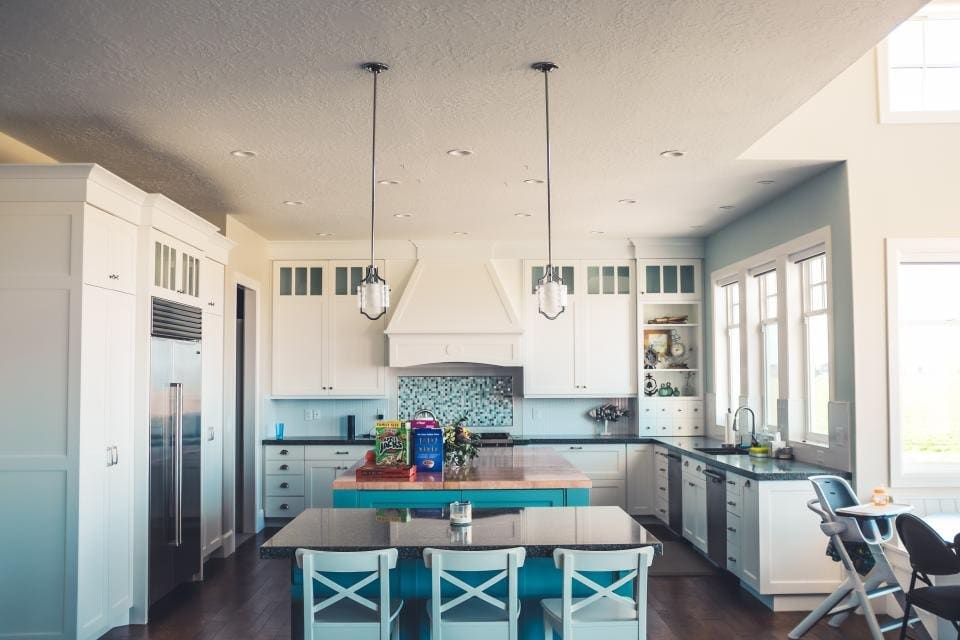 White kitchen with an island and pendant lights